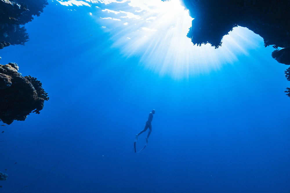 une personne nageant dans l’océan près d’une grotte