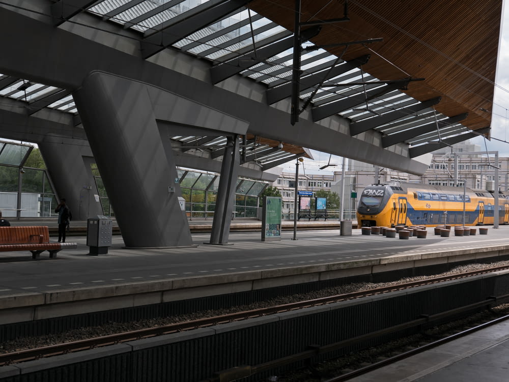a yellow and blue train at a train station
