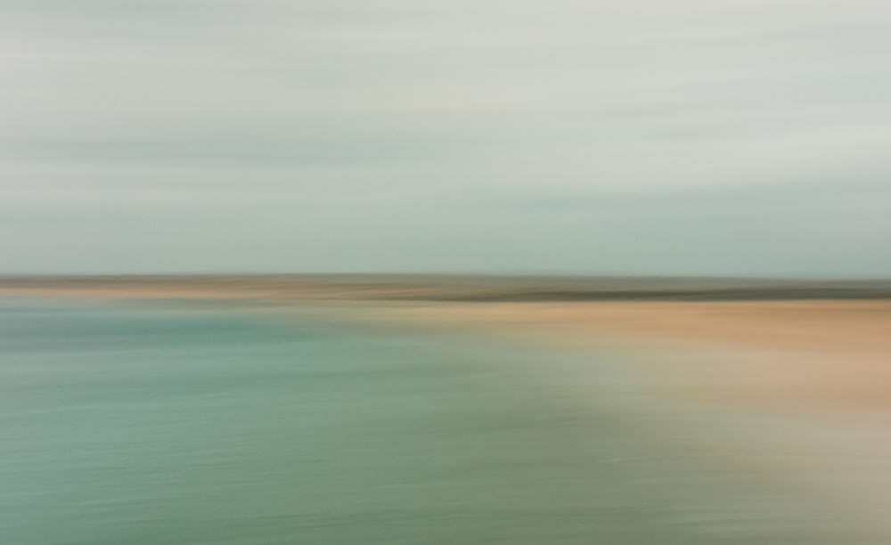 a blurry photo of a beach and water