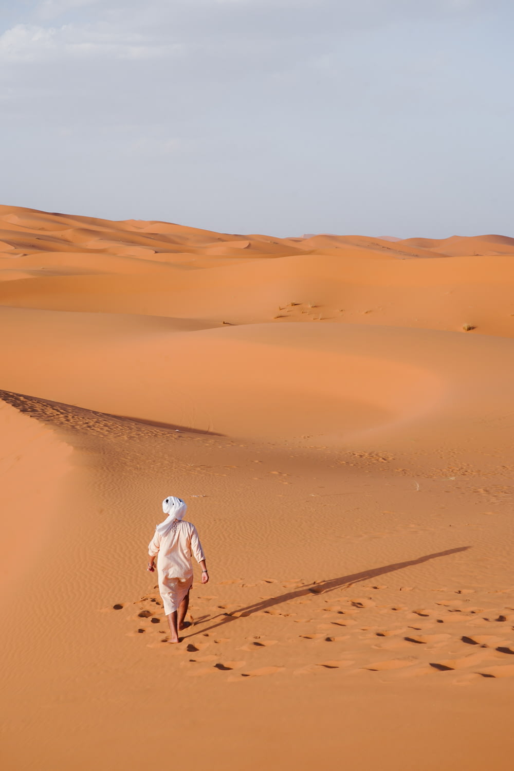 a person walking across a sandy field
