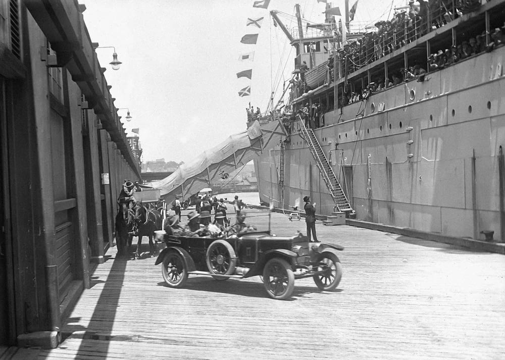a vintage photo of an old car on a dock