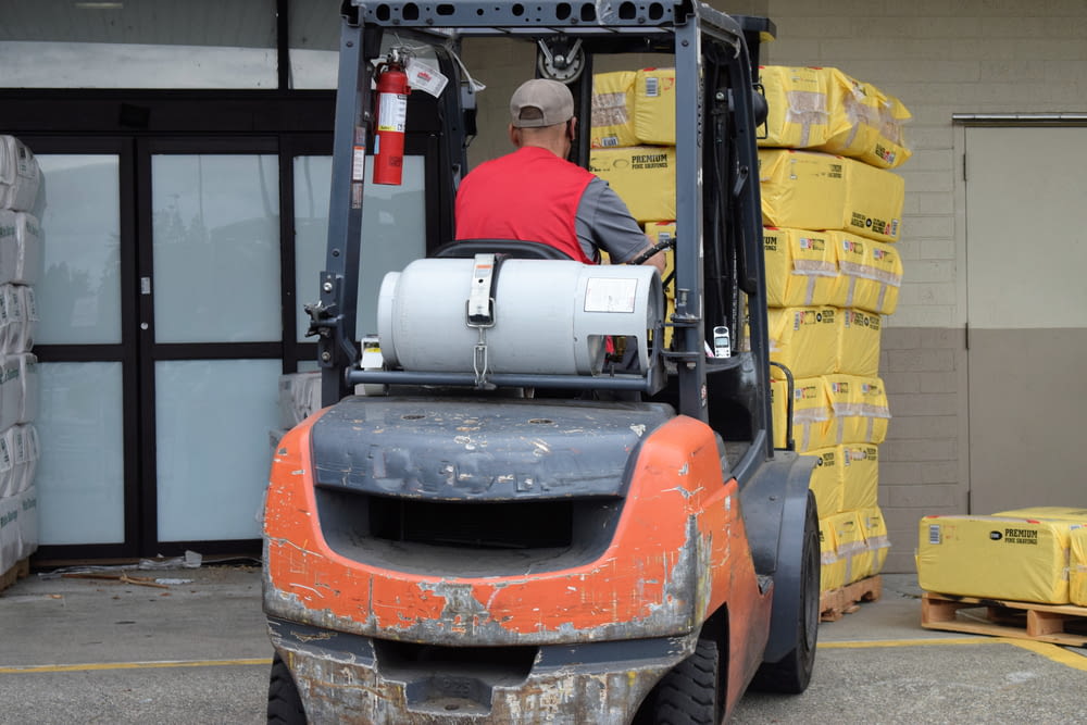 a man driving a forklift in a warehouse