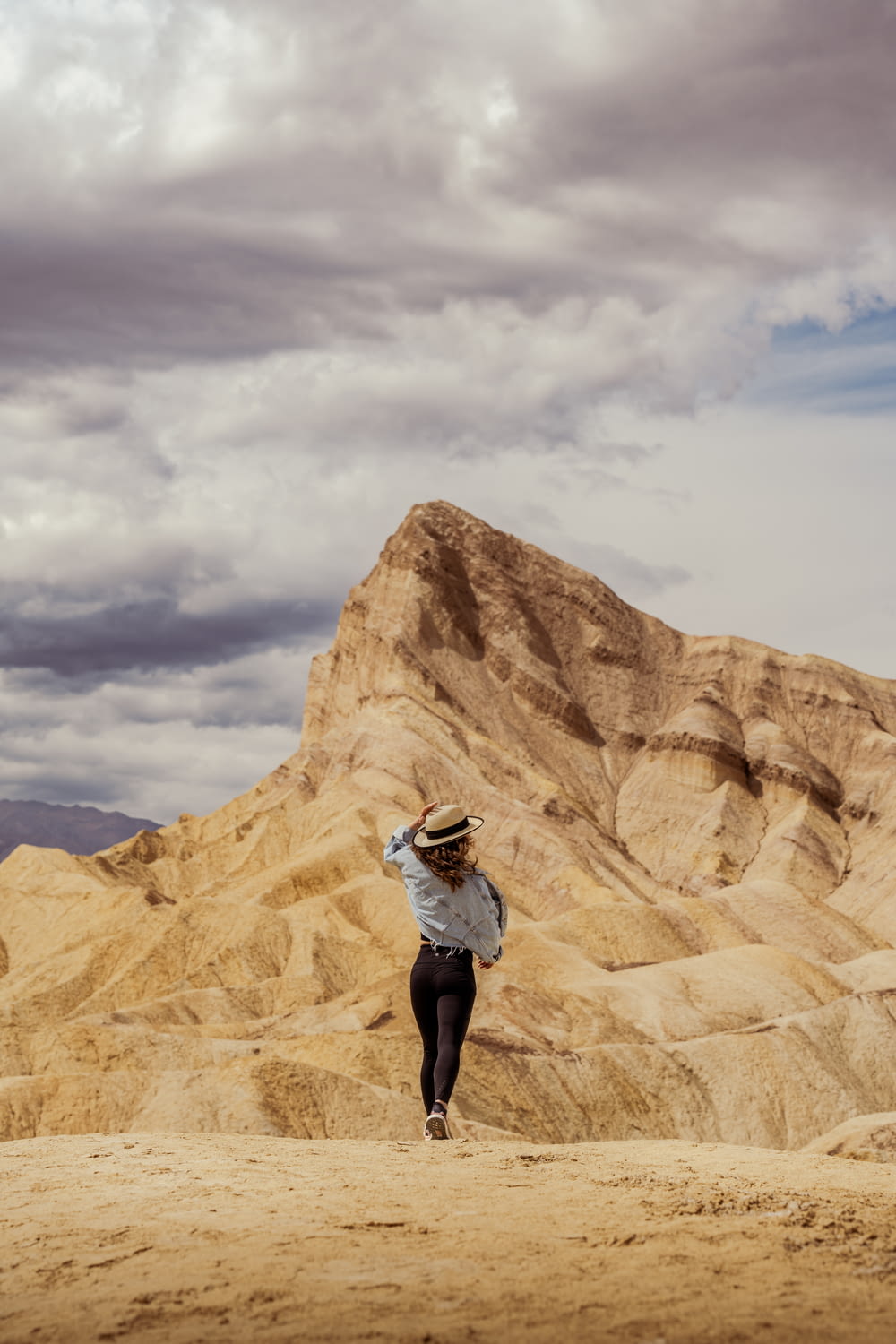 a woman in a hat is walking in the desert