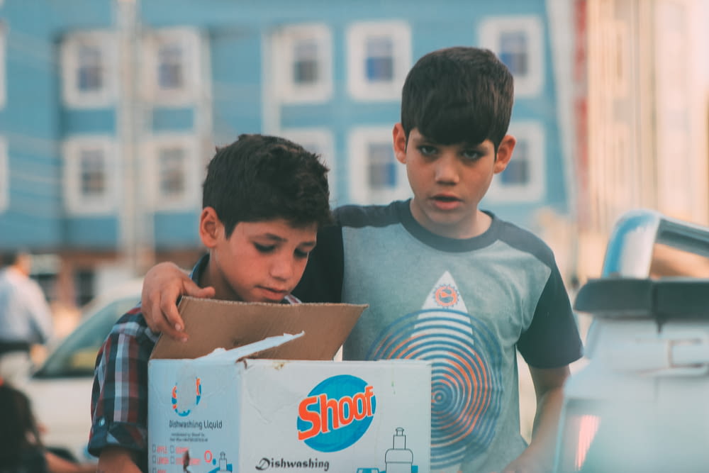 a boy and a boy are looking at a box