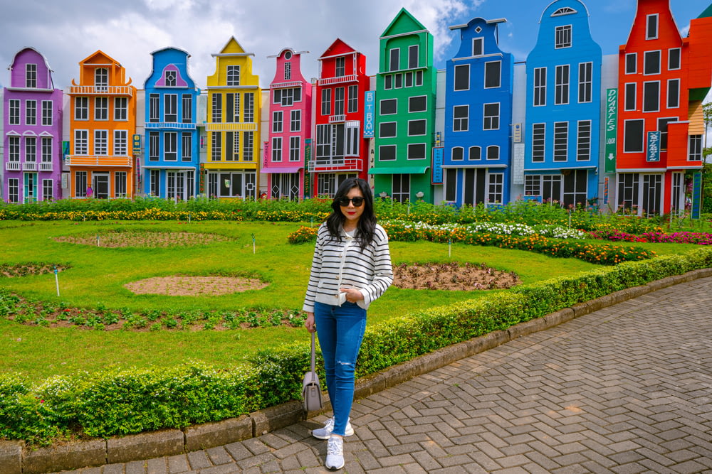 a woman standing in front of a row of colorful houses