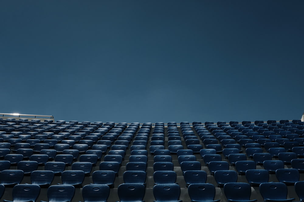 a stadium filled with blue seats under a blue sky