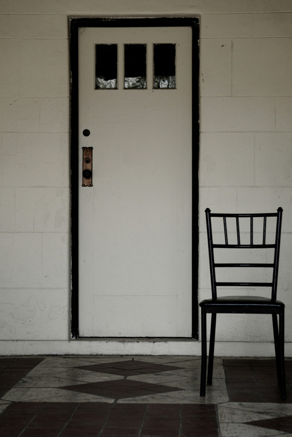a black chair sitting in front of a white door