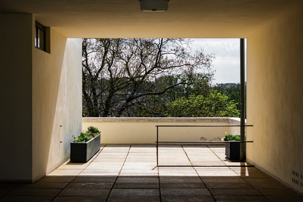 an open door leading to a balcony with a view of trees