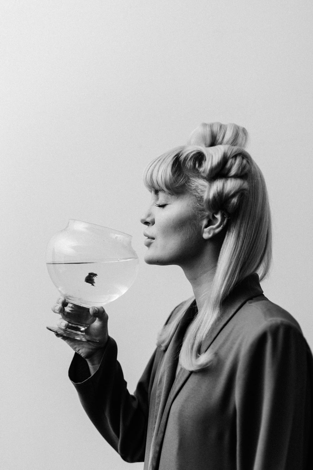 a black and white photo of a woman blowing bubbles