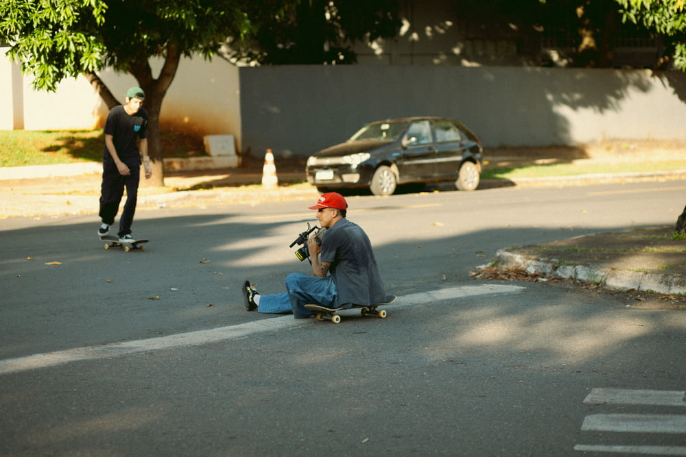 um homem sentado no chão em um skate