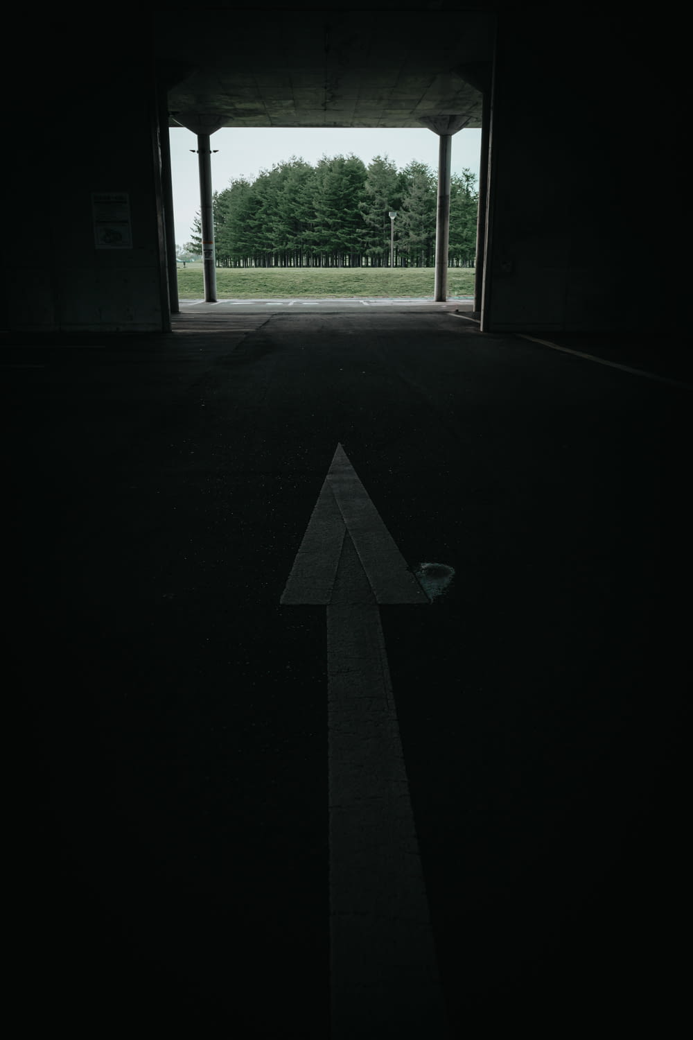 an empty parking garage with an arrow painted on the floor