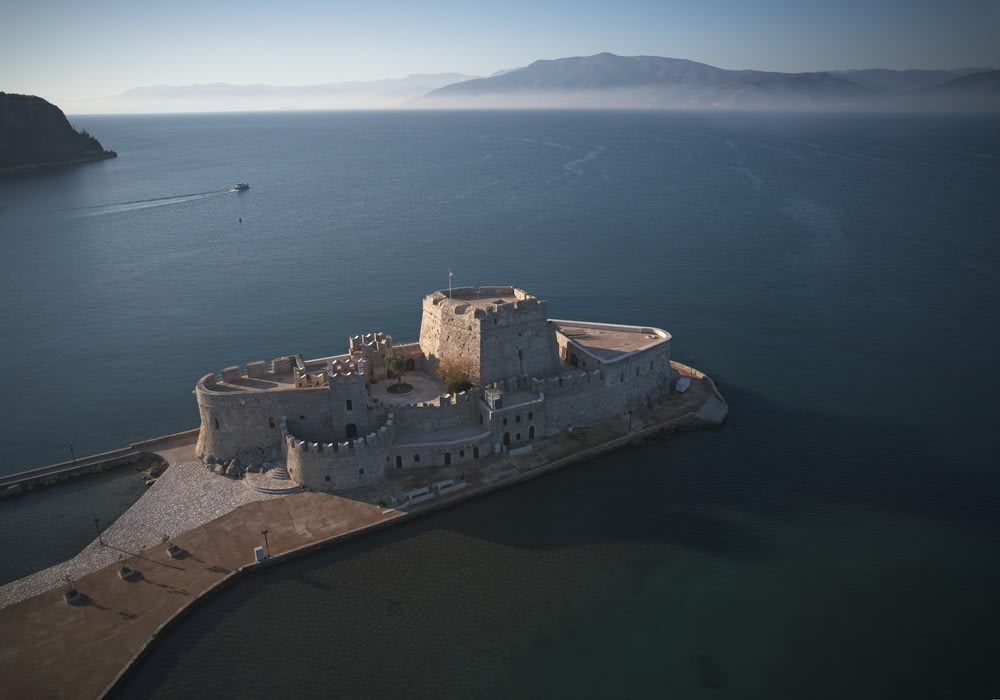 an aerial view of a castle in the middle of the ocean