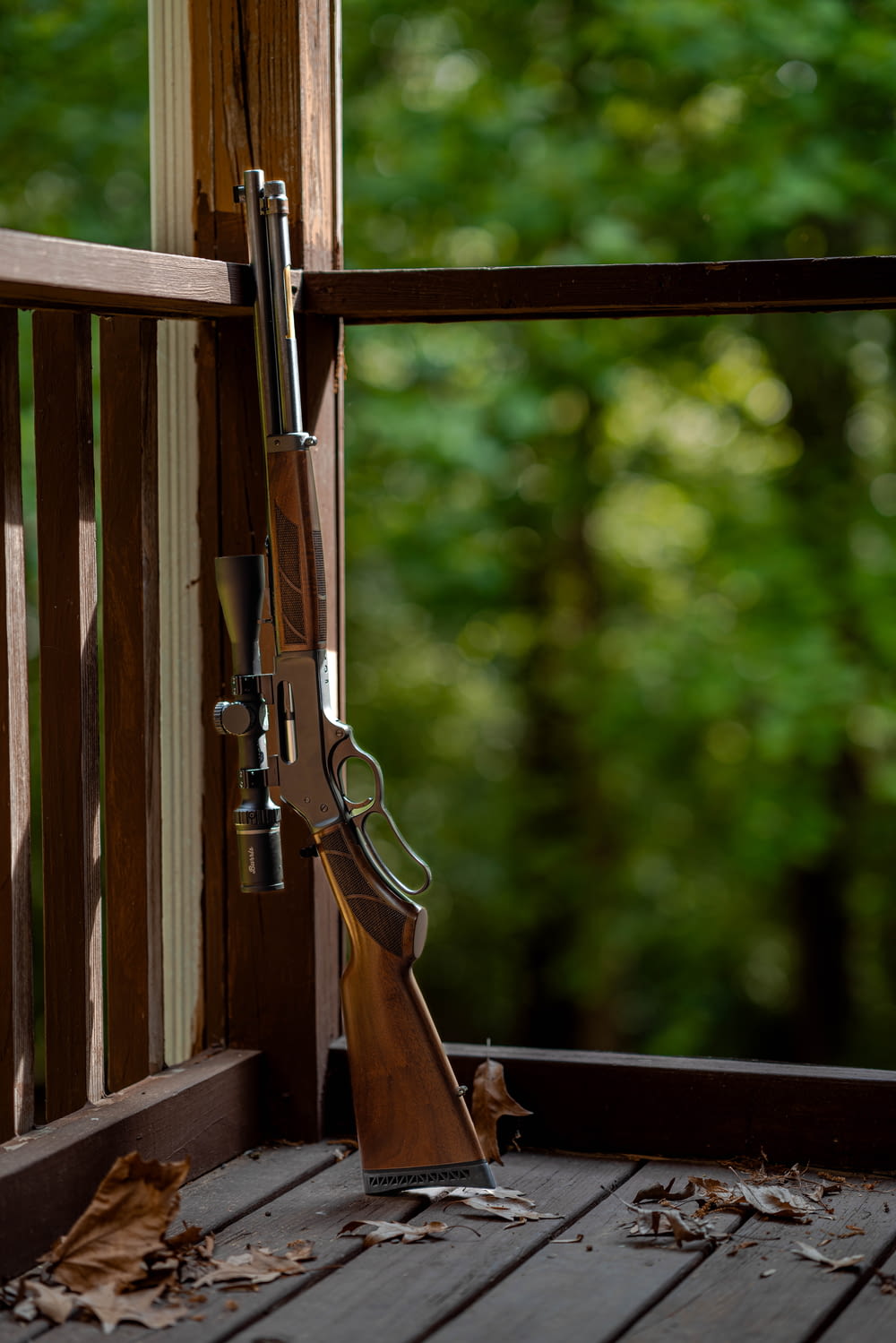 a rifle on a porch next to a window