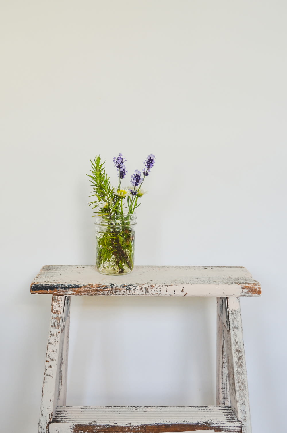 un banc en bois surmonté d’un vase de fleurs