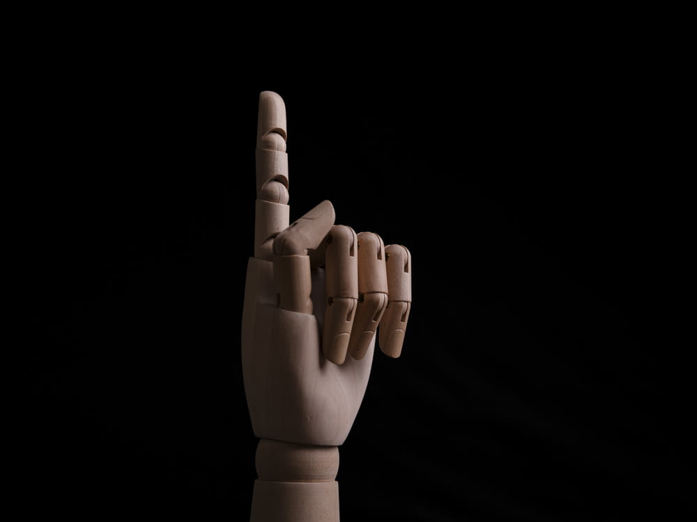 a hand making a peace sign on a black background