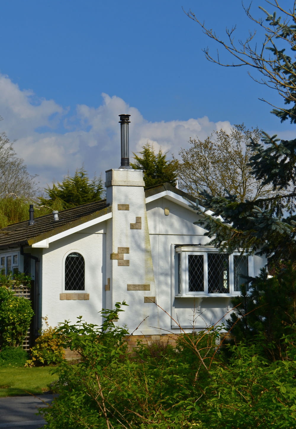 a small white house with a chimney and windows