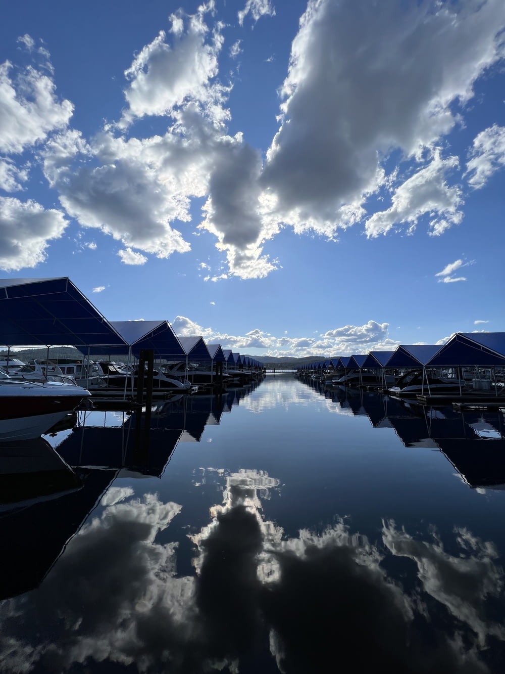 a body of water surrounded by boats under a cloudy blue sky