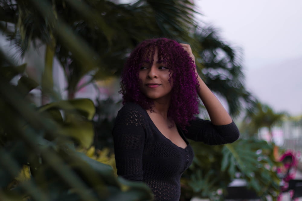 a woman with purple hair is posing for a picture