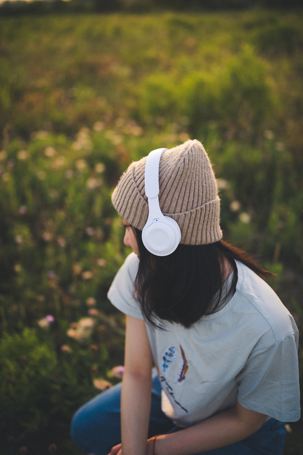 Une femme assise dans un champ avec des écouteurs