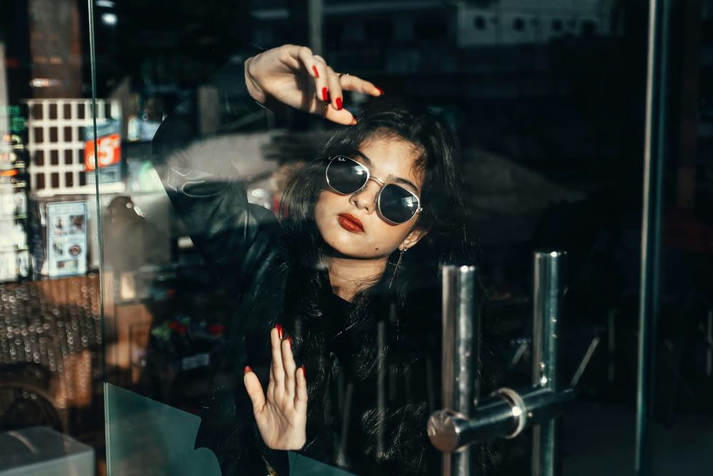 a woman with dark hair wearing sunglasses and a black jacket