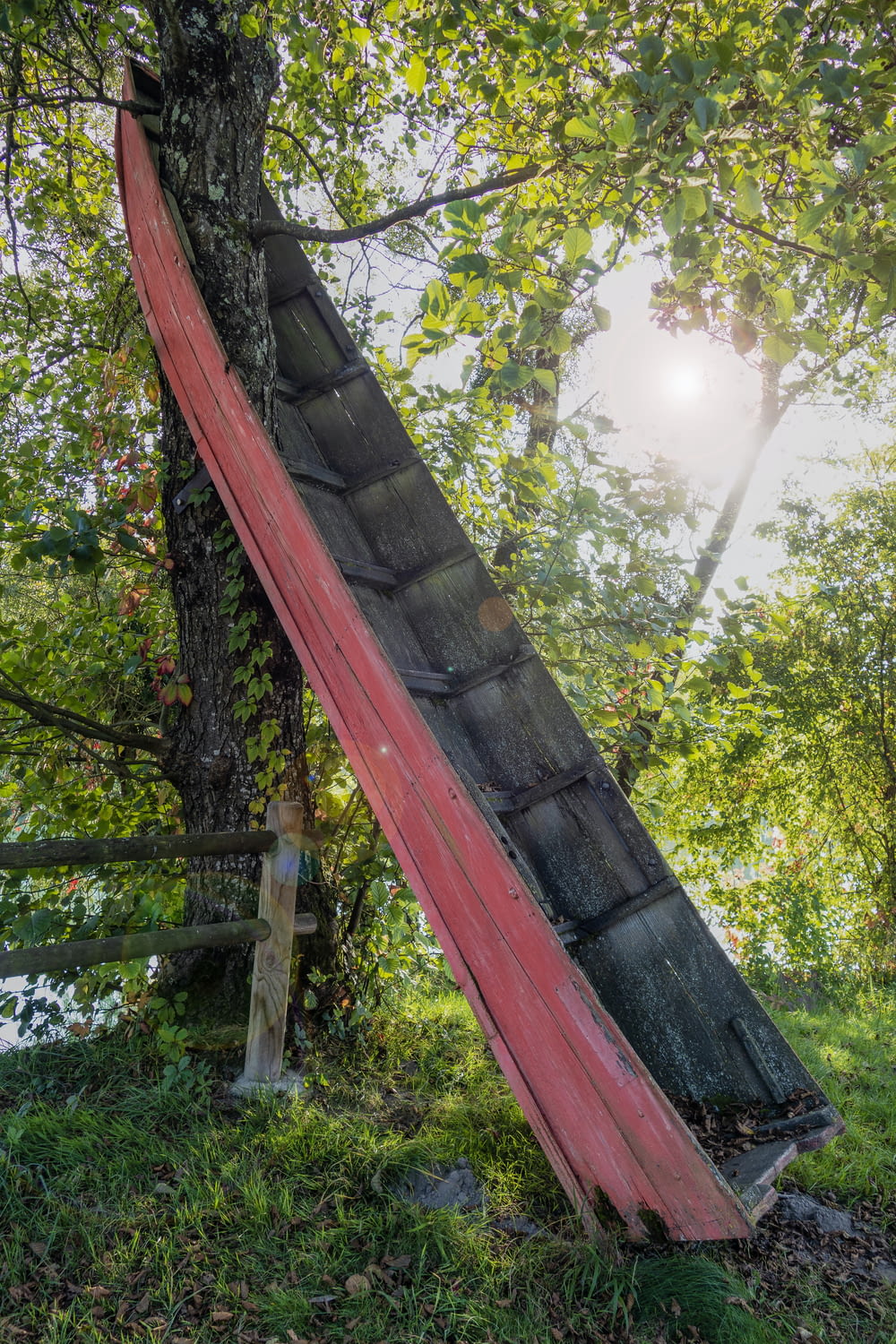 a broken down red umbrella sitting on top of a tree