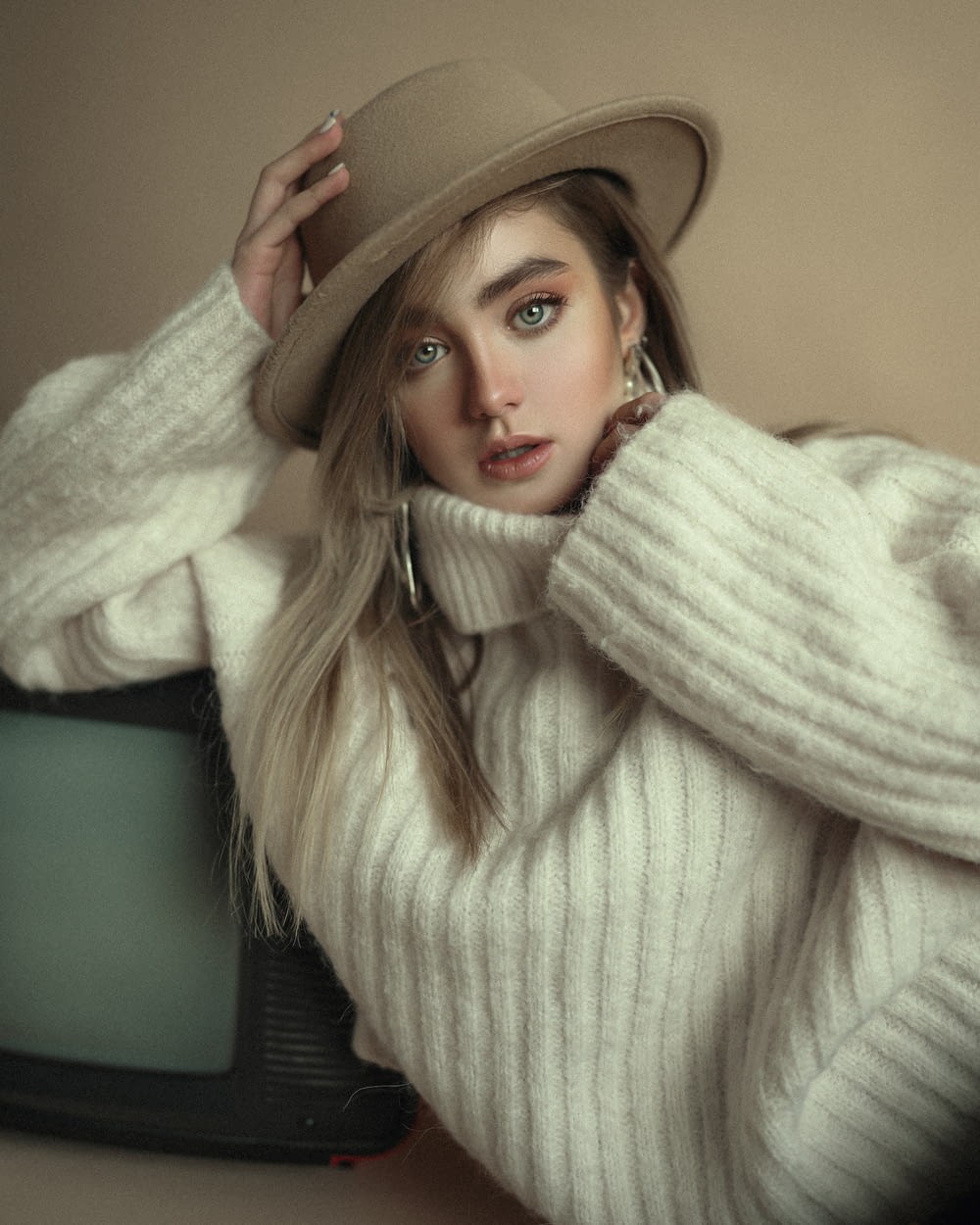 a woman in a white sweater and a hat