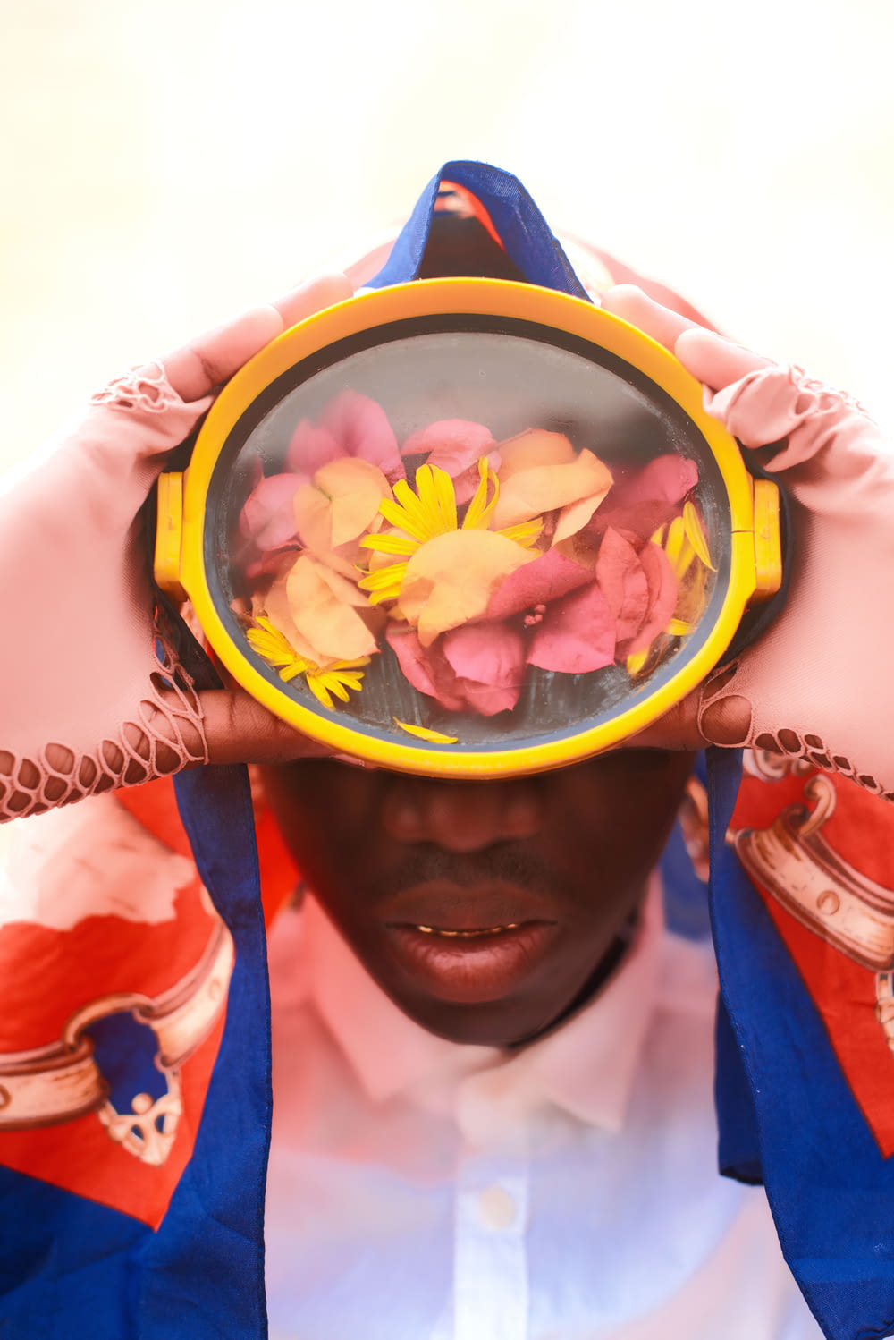 a man holding a mirror with flowers on it