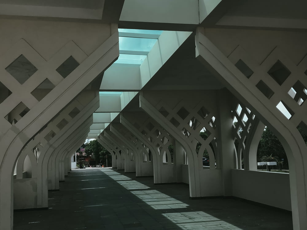 a row of white benches sitting under a skylight