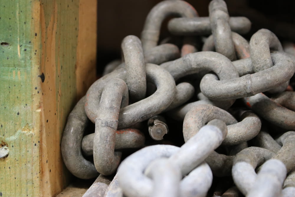 a pile of metal chains sitting on top of a wooden box