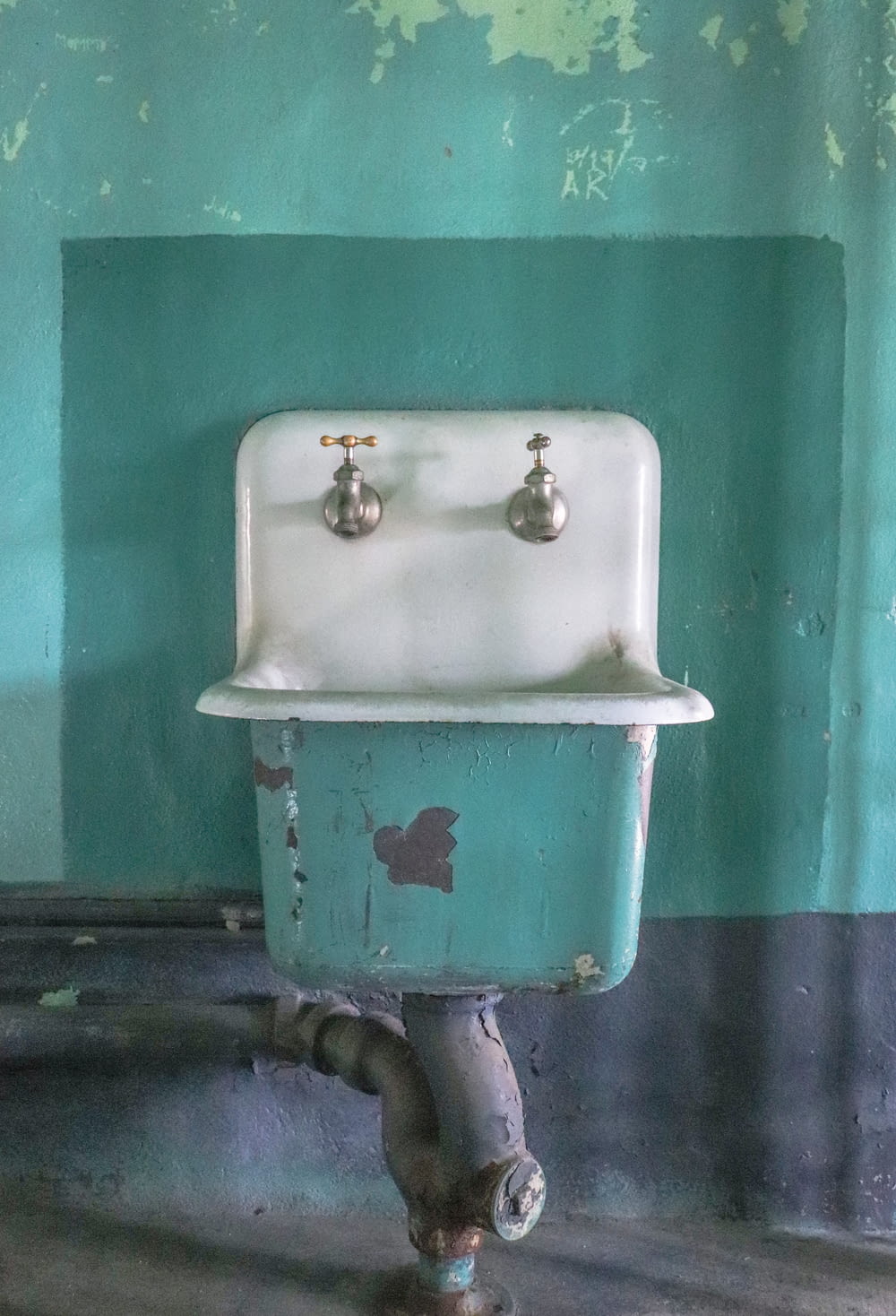 an old sink in a room with a green wall