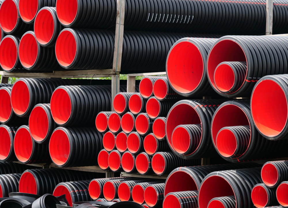 a pile of red and black pipes stacked on top of each other
