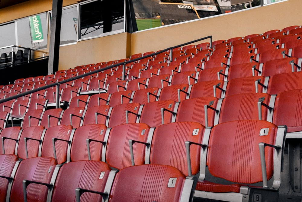 a row of empty red seats in a stadium