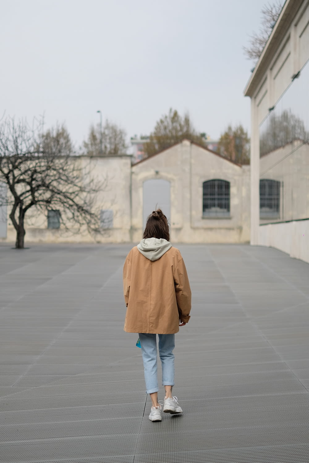 a woman in a brown jacket is walking
