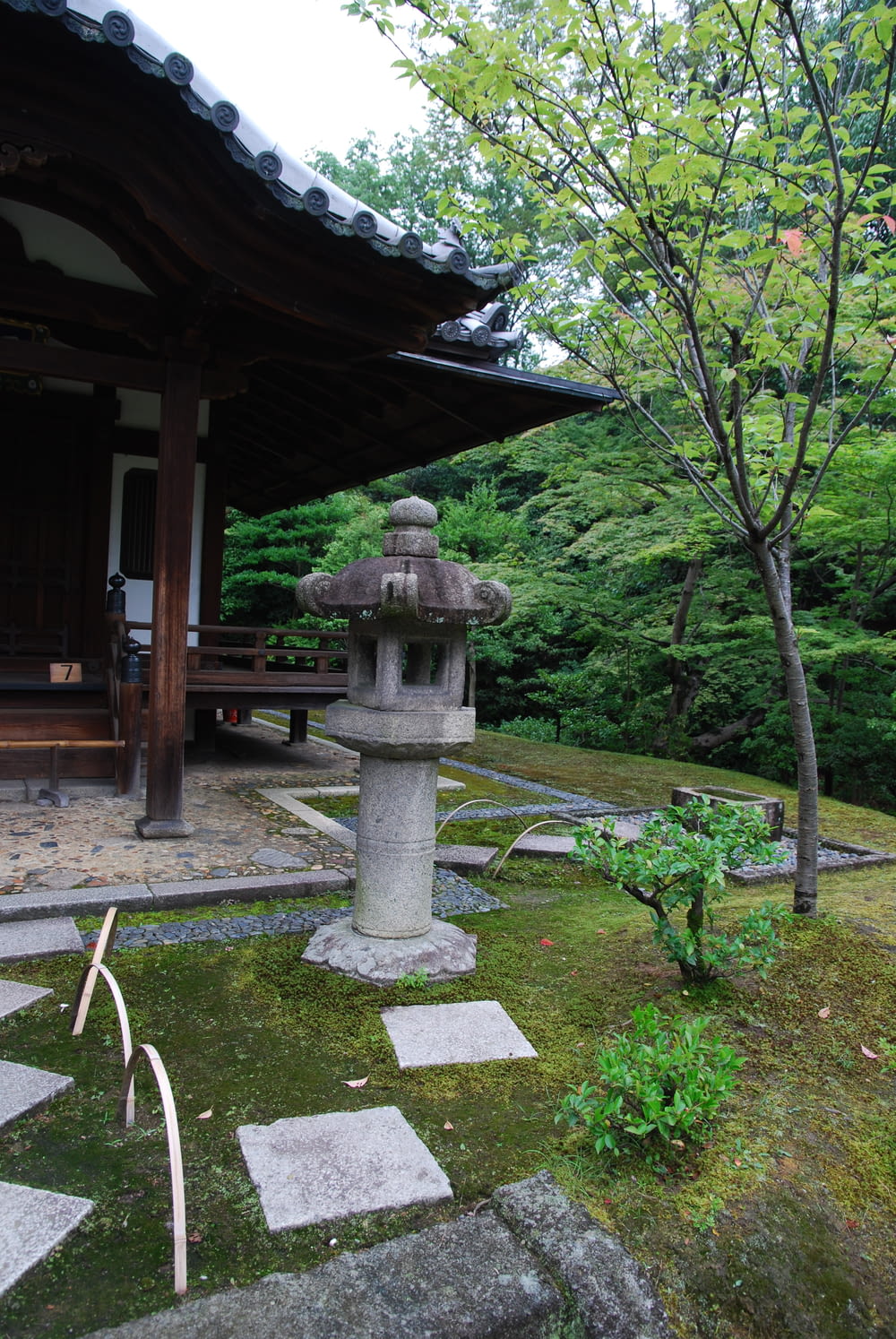 a stone lantern in a japanese garden with trees in the background