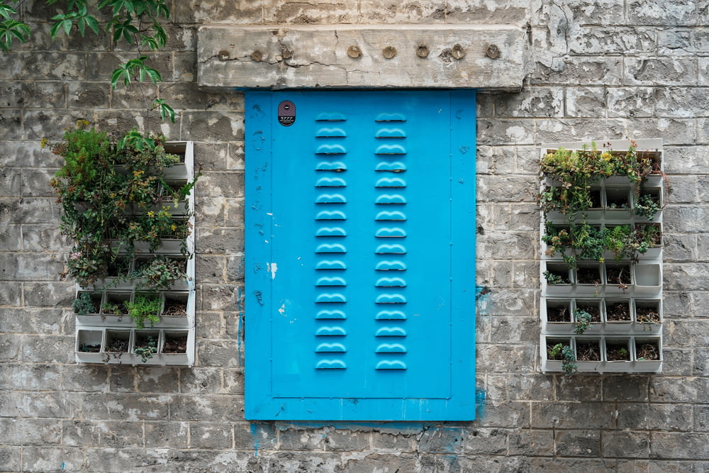 a blue door and window on a brick wall