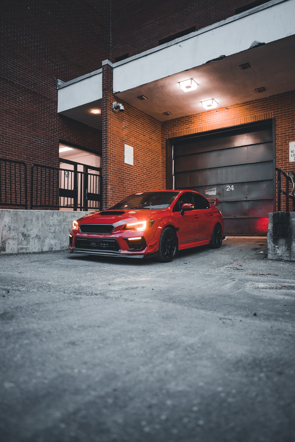a red car parked in front of a garage