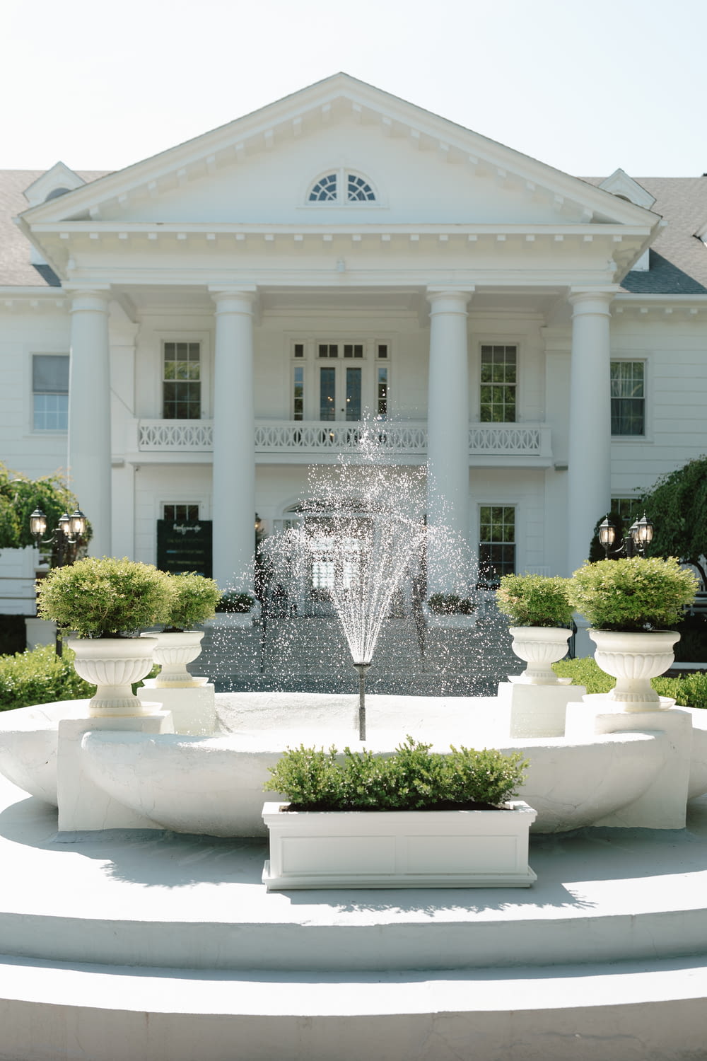 a large white building with a fountain in front of it