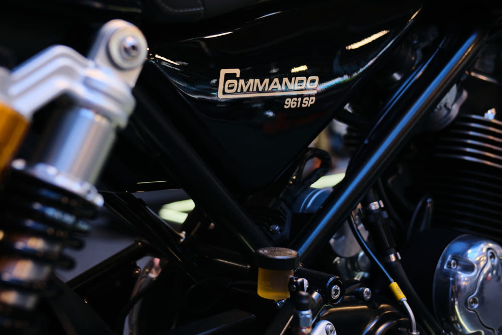 a close up of a black motorcycle with a white logo on it
