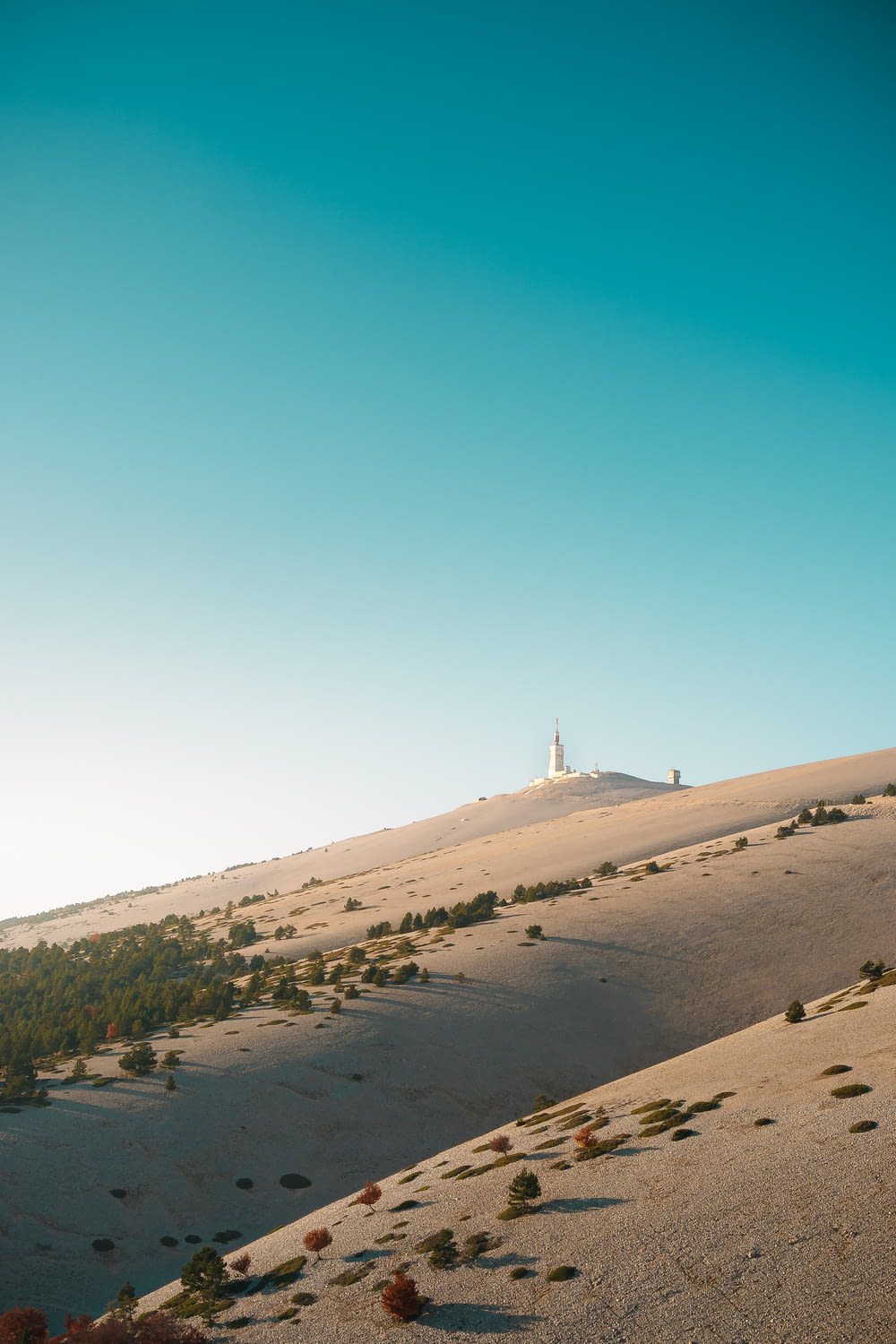 a white lighthouse on top of a hill in the desert