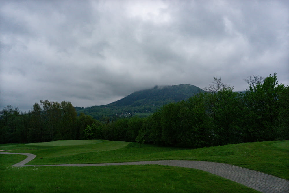 a green golf course with a mountain in the background