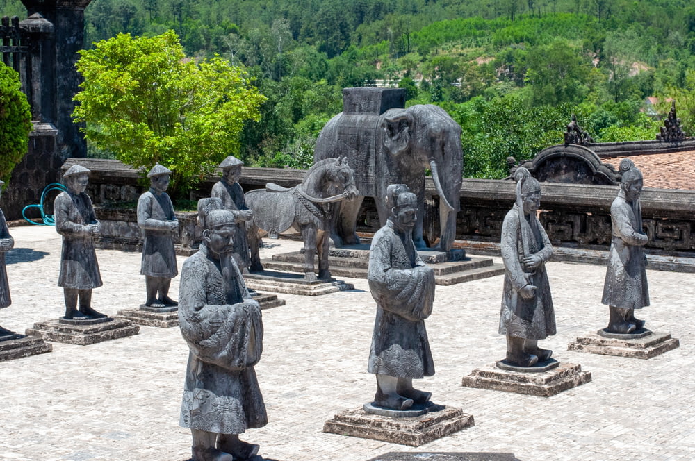 a group of statues of people and elephants