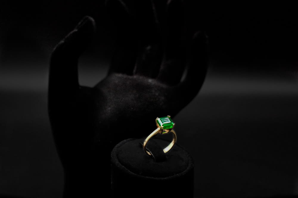a green ring sitting on top of a black stand
