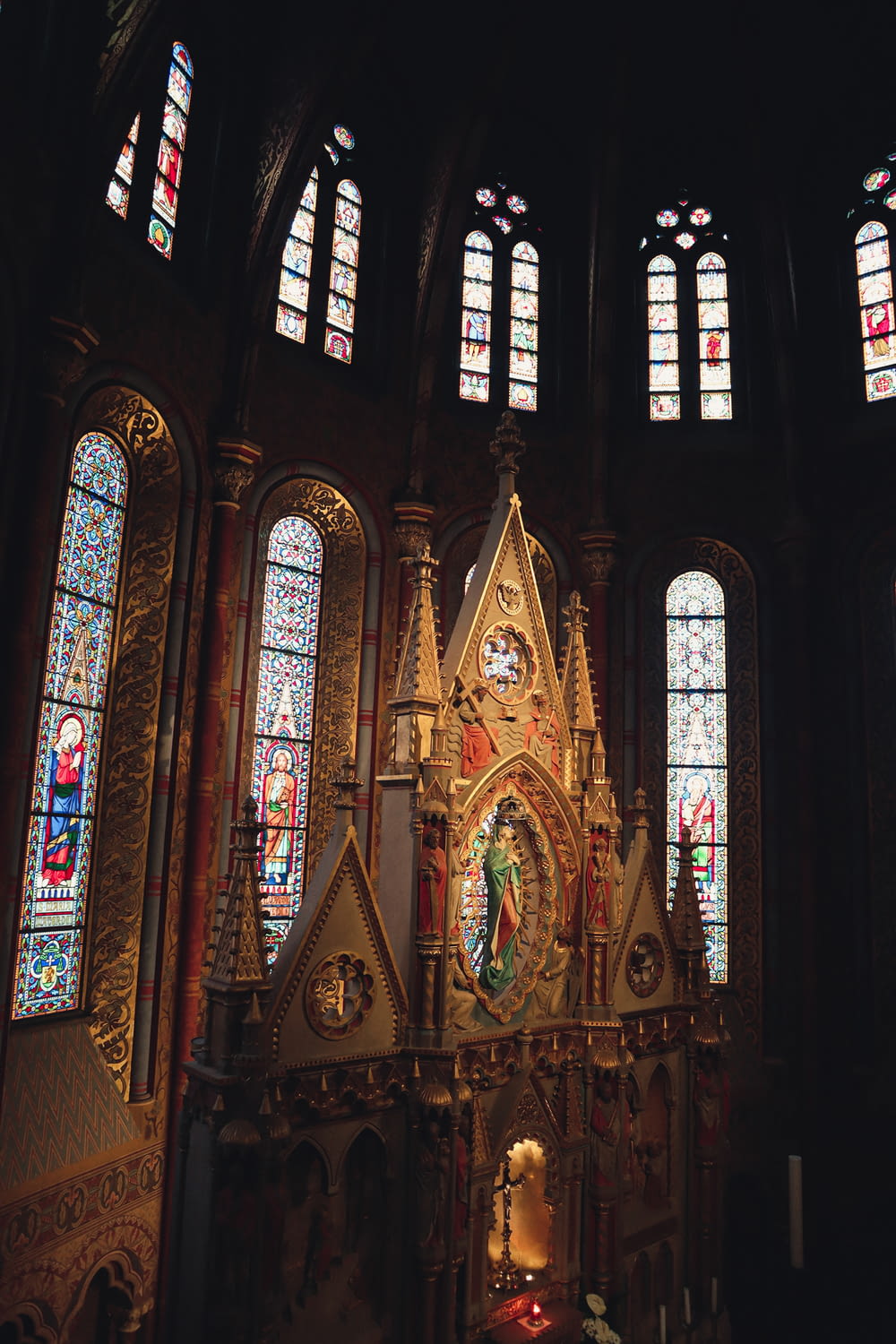 a church with stained glass windows and a gold alter