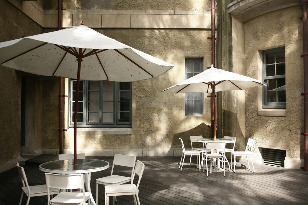 a group of tables and chairs with umbrellas