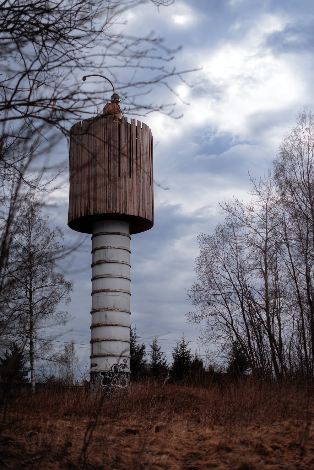 a tall wooden tower sitting on top of a dry grass field