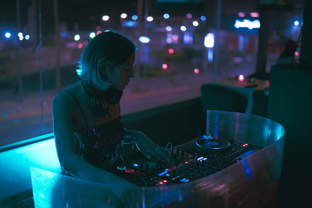 a woman sitting at a table with a dj controller