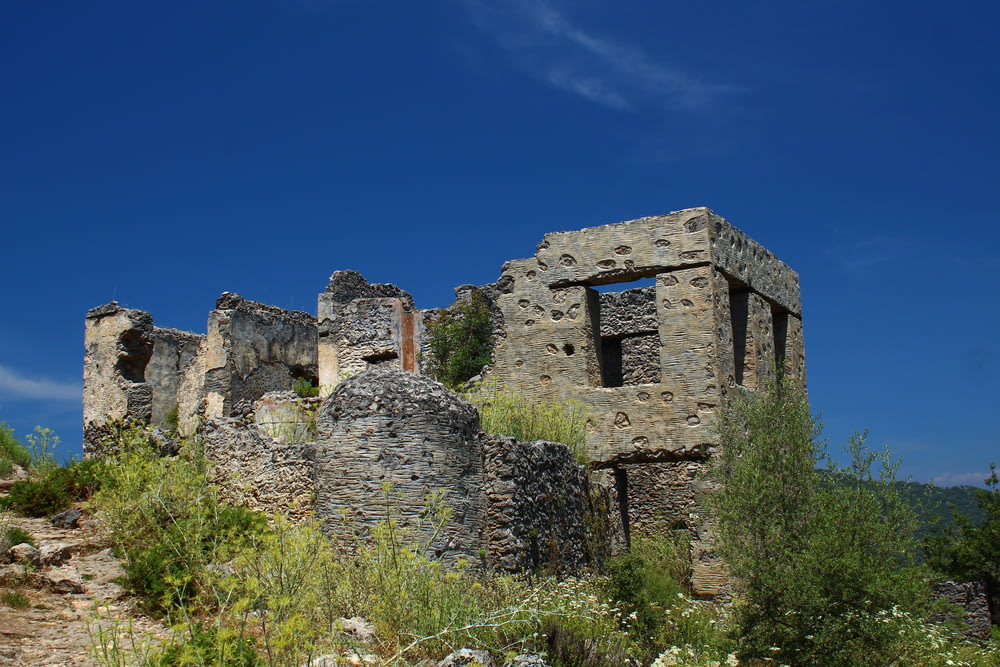 an old stone building sitting on top of a hill