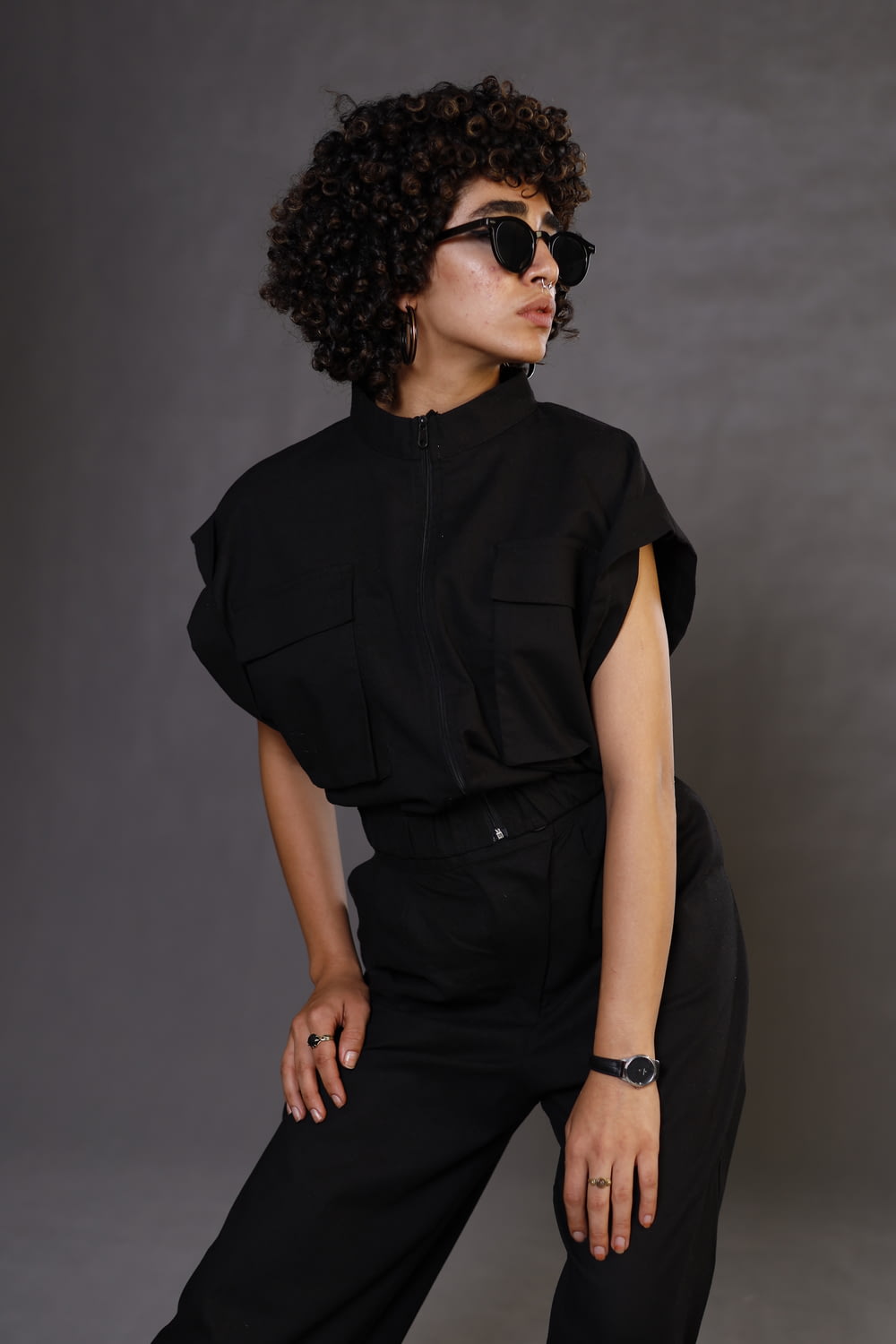 a woman wearing sunglasses and a black jumpsuit