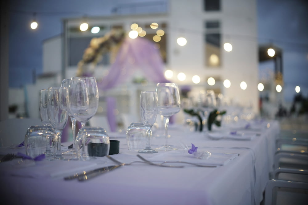 a table set up with wine glasses and silverware