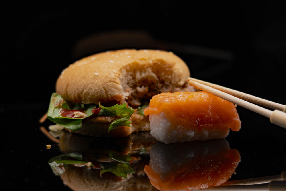 a close up of a sandwich with chopsticks on a table